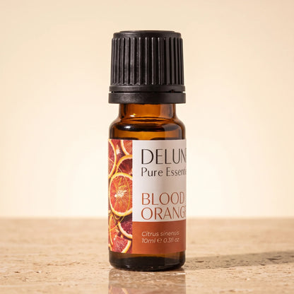 Delune Blood Orange Pure Essential Oil, 10ml amber glass bottle on warm travertine stone