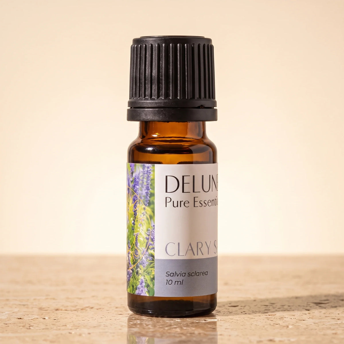 Delune Clary Sage Pure Essential Oil, 10ml amber glass bottle on warm travertine stone